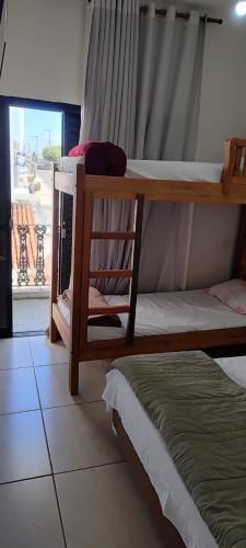 a bedroom with two bunk beds and a window at Hostel da Moda in Passos