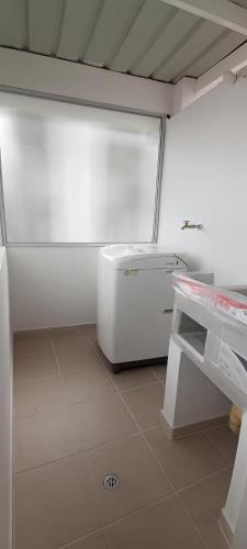 - une cuisine avec un appareil blanc dans une chambre dans l'établissement Elegancia Urbana: Aparta Estudio, à Pasto