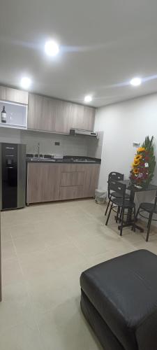 Cette chambre dispose d'une cuisine avec une table et des chaises. dans l'établissement Elegancia Urbana: Aparta Estudio, à Pasto
