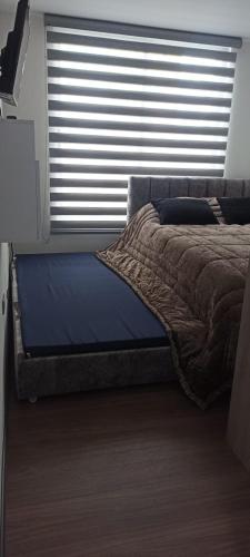 Ce lit se trouve dans un dortoir doté d'une grande fenêtre. dans l'établissement Elegancia Urbana: Aparta Estudio, à Pasto