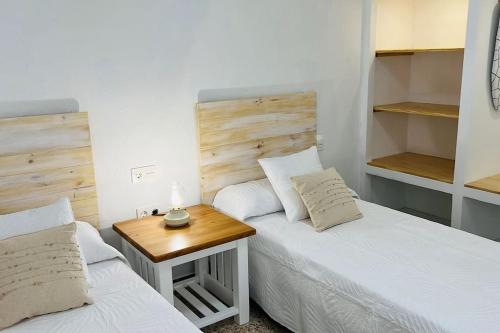 a bedroom with two beds and a wooden table at Famara Frontsea house in Famara