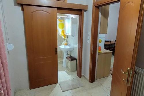 a bathroom with a sink and a toilet and a door at Δ2 in Dhidhimótikhon