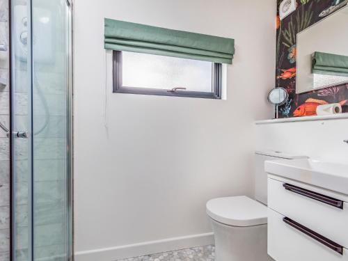 a bathroom with a toilet and a window at Pass the Keys Charming Bosham Garden Lodge in Chichester
