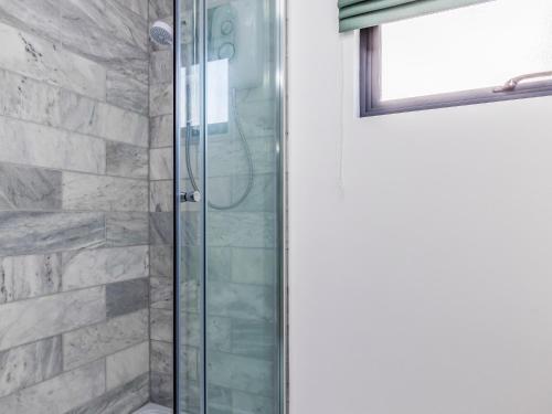 a shower with a glass door in a bathroom at Pass the Keys Charming Bosham Garden Lodge in Chichester
