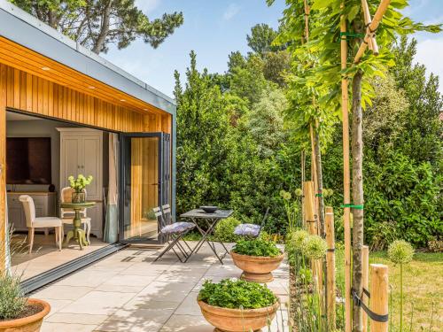 a garden with a patio with a table and chairs at Pass the Keys Charming Bosham Garden Lodge in Chichester