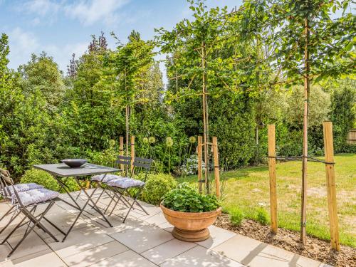 a patio with a table and chairs and trees at Pass the Keys Charming Bosham Garden Lodge in Chichester