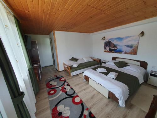 a bedroom with two beds and a wooden ceiling at Belvedere La Cristina in Corbeni