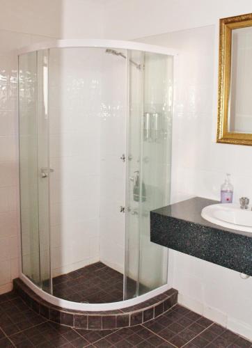 a bathroom with a glass shower and a sink at Hatchers Richmond Manor in Richmond