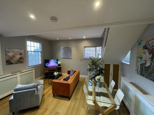 a living room with a couch and a tv at Luxury 3-bed Victorian Townhouse Hosted by Hutch Lifestyle in Leamington Spa