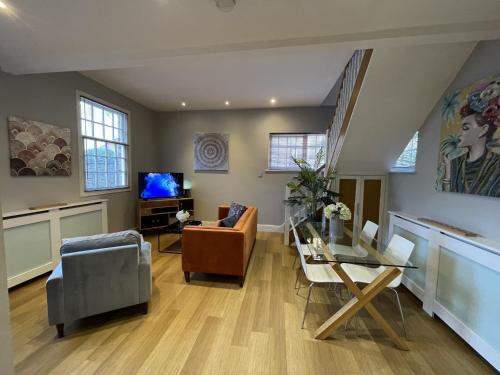 ein Wohnzimmer mit einem Glastisch und Stühlen in der Unterkunft Luxury 3-bed Victorian Townhouse Hosted by Hutch Lifestyle in Leamington Spa