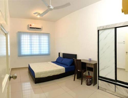 a bedroom with a bed and a desk with a computer at A Cool place to stay in Seremban