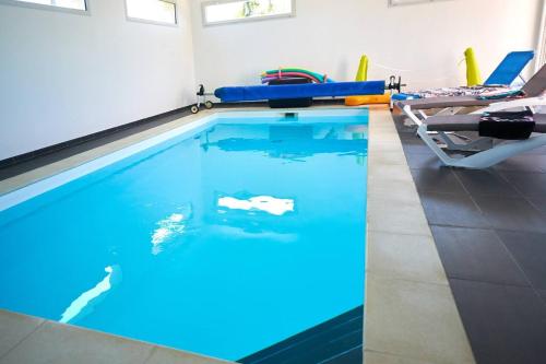 - une piscine intérieure avec éclairage bleu dans une chambre dans l'établissement Ti Treber, à Brignogan-Plage
