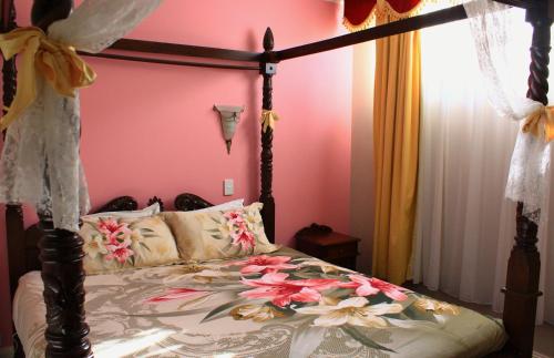 a bedroom with a canopy bed with flowers on it at Hatchers Richmond Manor in Richmond
