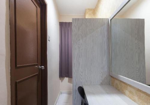 a bathroom with a mirror and a sink and a door at Hotel Pulai Ipoh in Ipoh