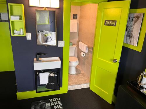 a bathroom with a yellow door and a sink at Mari Jean Hotel - Adults Only Gay Hotel in St. Petersburg