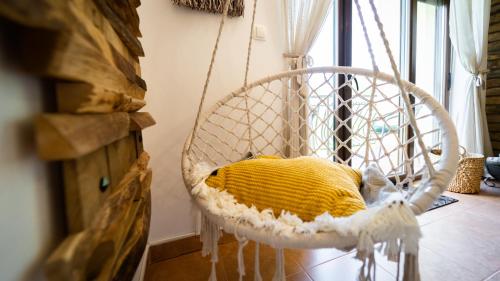 a white basket with a yellow pillow in a room at Specious Apartment Manitu in forest countryside in Fužine
