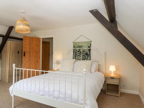 um quarto com uma cama branca num quarto em Rose Cottage at Treaslake Farm em Honiton