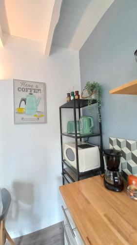 a kitchen with a counter and a shelf at Les Appartements du 104 in Saint-Jean-de-Monts