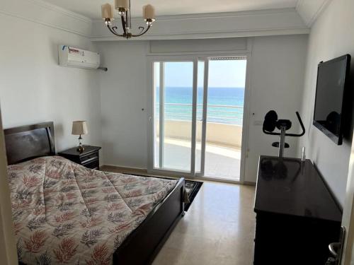 a bedroom with a bed and a view of the ocean at Résidence Le Monaco Sousse in Sousse