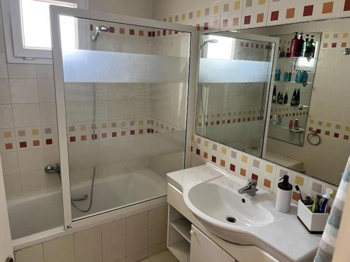 y baño con ducha, lavabo y bañera. en Résidence Le Monaco Sousse en Sousse
