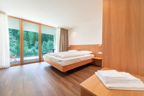 a bedroom with a bed and a large window at Greva Apartments 2 in Santa Cristina in Val Gardena