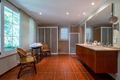 a bathroom with a sink and a table and chairs at Torre Lolita - House in Lleida for 8 with pool and tennis court in Lleida