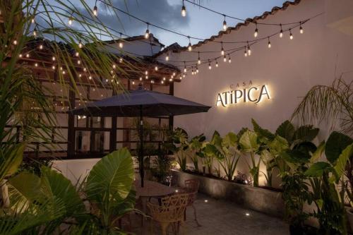 a restaurant with an umbrella and a sign on the wall at Casa Atipica in San Cristóbal de Las Casas
