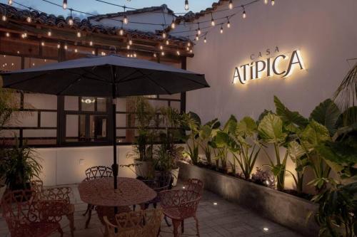 a patio with a table and chairs and an umbrella at Casa Atipica in San Cristóbal de Las Casas
