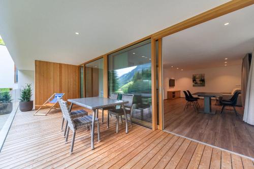 a room with a table and chairs on a deck at Greva Apartments 2 in Santa Cristina in Val Gardena