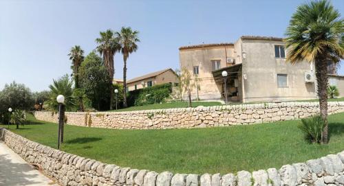 a stone retaining wall in front of a house at Agriturismo Giannavi in Palazzolo Acreide