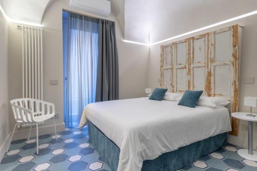sypialnia z dużym łóżkiem i krzesłem w obiekcie Biuti Suite Apartment w Katanii