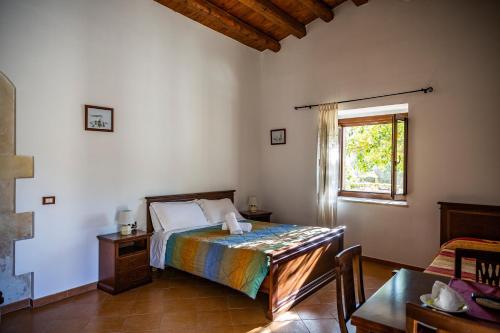 パラッツォーロ・アクレイデにあるAgriturismo Giannaviのベッドルーム1室(ベッド1台、窓、テーブル付)