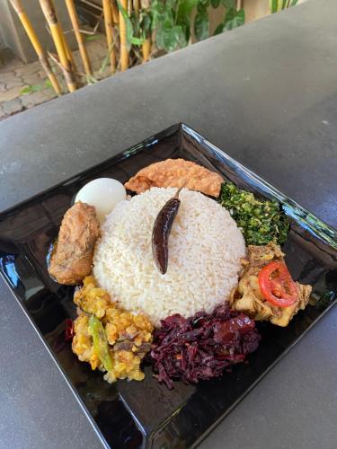 a plate of food with rice and vegetables on a table at Hotel Tinaya in Dambulla