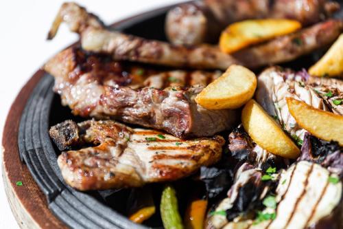 a plate of food with meat and vegetables at Agriturismo Giannavi in Palazzolo Acreide