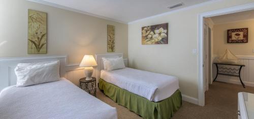 a hotel room with two beds and a lamp at Villas by the Sea Resort & Conference Center in Jekyll Island