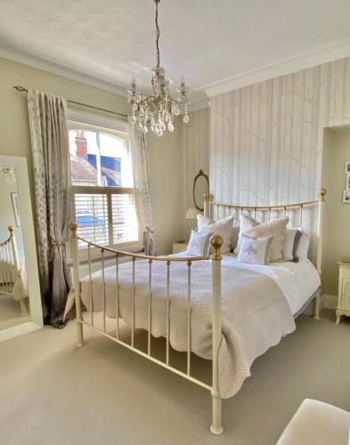 a bedroom with a bed with white pillows and a chandelier at City Apartments - 66 Scott Street in York