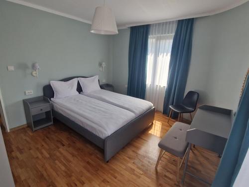 a bedroom with a bed and a desk and a window at Flowers Apartments in Nesebar