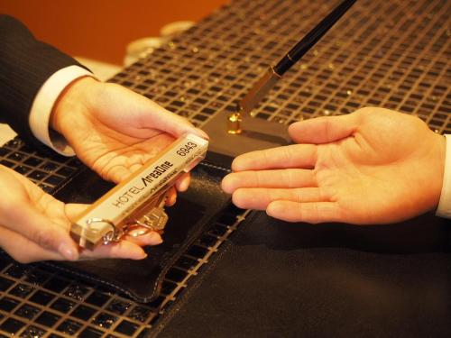 a man in a suit is holding a piece ofasuring at Hotel AreaOne Kushiro in Kushiro