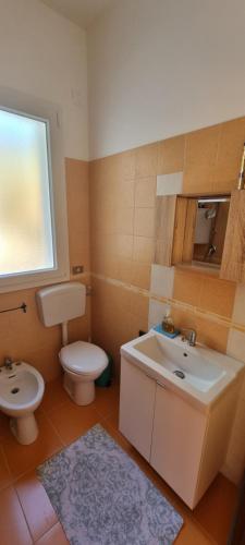 a bathroom with a toilet and a sink and a mirror at Villa Ecnomo in Licata