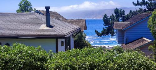 a blue house with a view of the ocean at AmbienteMar Cabañas in Papudo