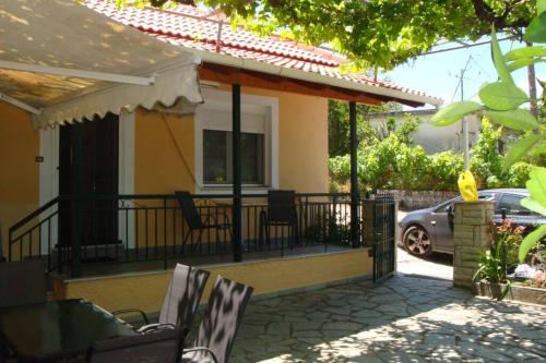 a porch of a house with chairs and a car at Grapes and Roses in Igoumenitsa
