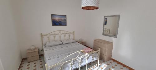 Habitación blanca con cama y espejo en Villa Ecnomo, en Licata
