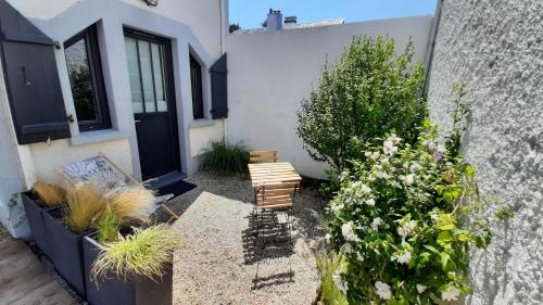 a garden with two benches and flowers next to a building at Les Appartements du 104 in Saint-Jean-de-Monts