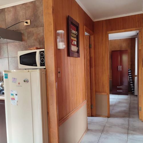 a kitchen with a refrigerator and a microwave at AmbienteMar Cabañas in Papudo
