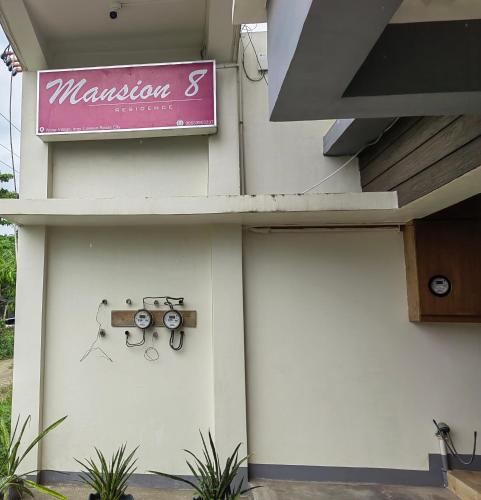 a sign on the side of a building with a door at Mansion 8 Residences in Roxas City