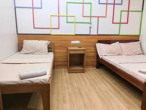 a room with two beds and a table in it at Mansion 8 Residences in Roxas City