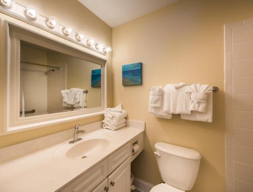 a bathroom with a sink and a toilet and a mirror at Villas by the Sea Resort & Conference Center in Jekyll Island