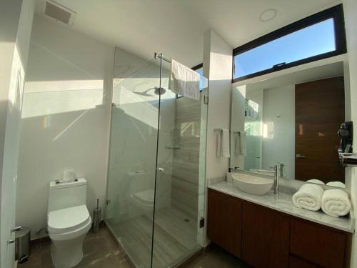 a bathroom with a glass shower and a toilet at Depa enfrente del Hotel RIU @serra in Guadalajara