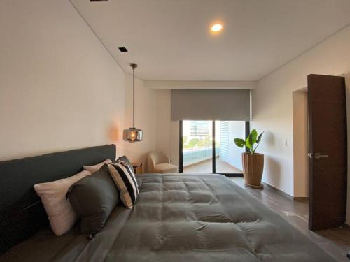 a bedroom with a large bed with a couch at Depa enfrente del Hotel RIU @serra in Guadalajara