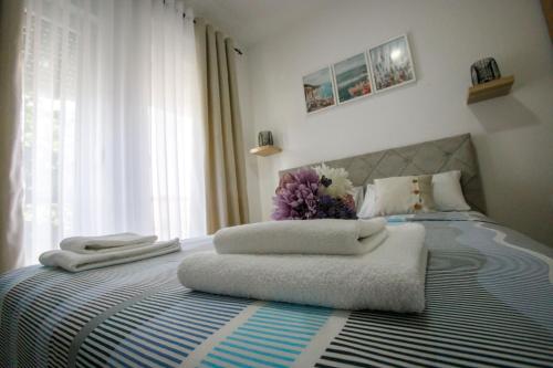 a bedroom with a bed with towels on it at Apartman Paratetis 2 in Palić